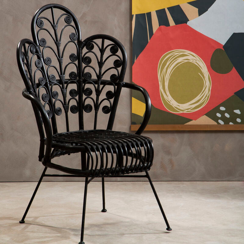 Decorative black metal chair in a room with abstract art on the wall.