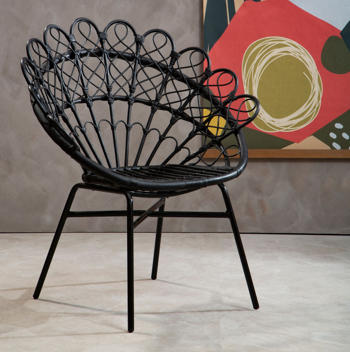 Black wicker chair in a room with abstract art on the wall