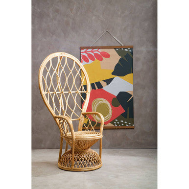 Wicker chair against a gray wall with a colorful abstract painting.