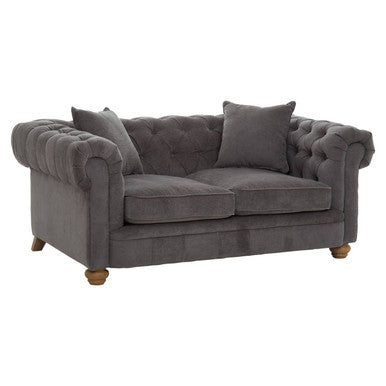Gray velvet sofa with tufted backrest on a white background