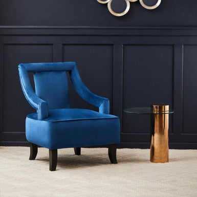 Blue armchair in a room with decorative wall art and a small table.