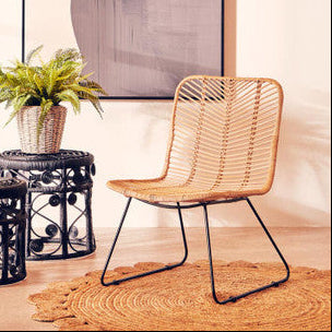 Wicker chair and side tables with a abstract painting in a room.
