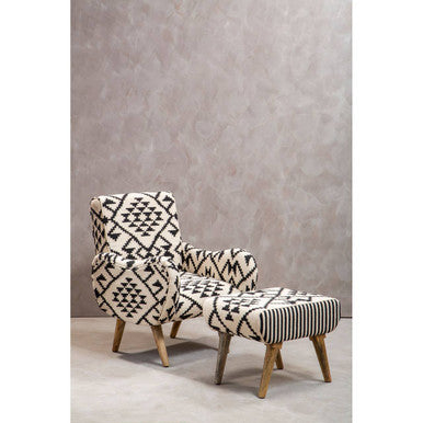 Patterned armchair and ottoman set against a gray wall.