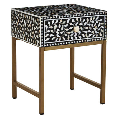 Decorative side table with black and white patterned top on a white background