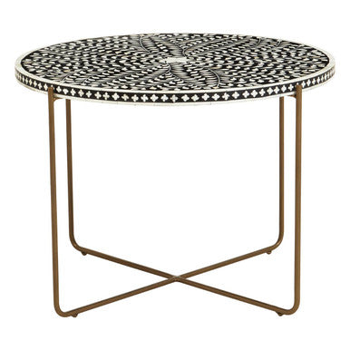 Round side table with black and white patterned top and brass base on a white background