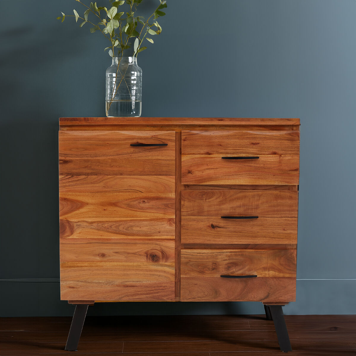 Wooden dresser with four drawers against a dark gray wall.