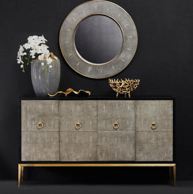 Decorative console table with a round mirror, vase, and decorative items against a black background