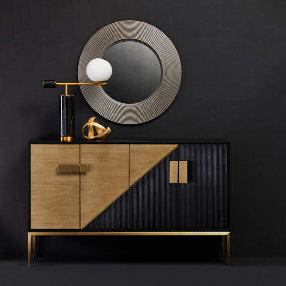 Modern black and gold cabinet with a round mirror on a dark wall