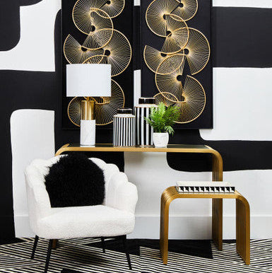 Modern interior design with abstract wall art, white armchair, and gold side table.