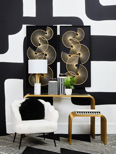 Modern interior design with abstract wall art, white armchair, and gold side table.