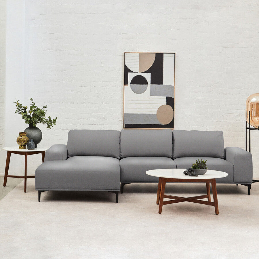 Modern living room with a gray sectional sofa, abstract art, and side table.