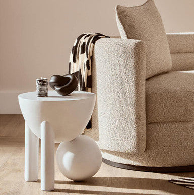 Beige armchair with a white side table in a living room setting