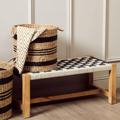 Wooden bench with woven seat and backrest, accompanied by two wicker baskets.