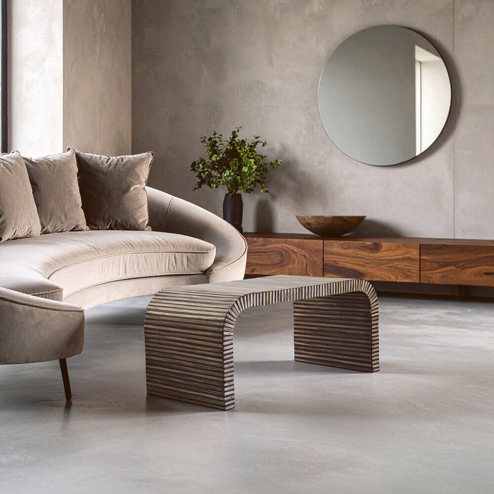Modern living room with a beige sofa, wooden coffee table, and decorative elements.