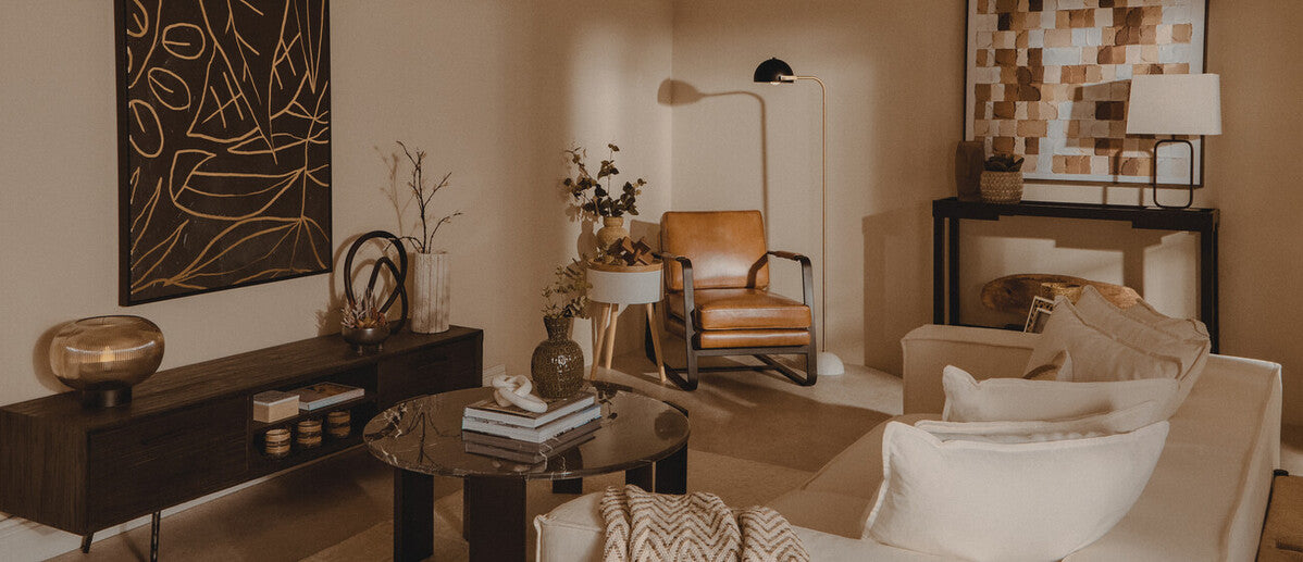 Modern living room with a sofa, armchair, coffee table, and decorative items.