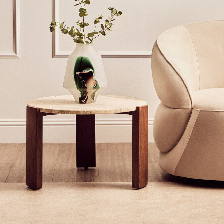 Wooden and travertine coffee table with a vase and plant in a living room setting