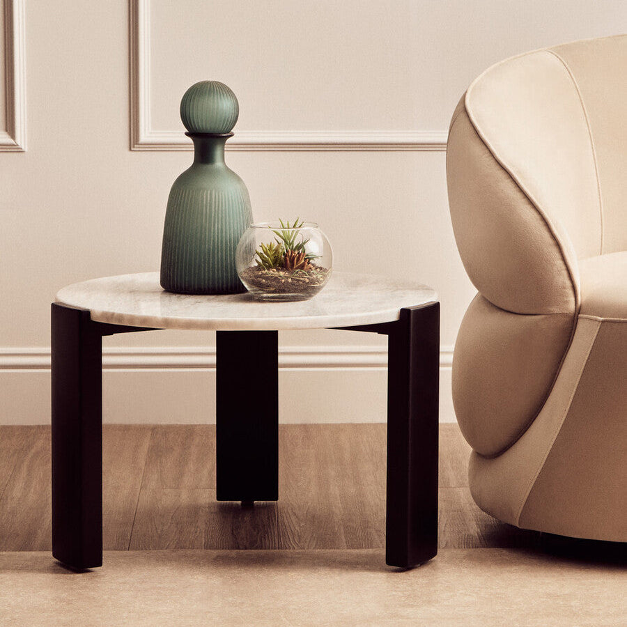 Modern living room with a side table, vase, and chair.