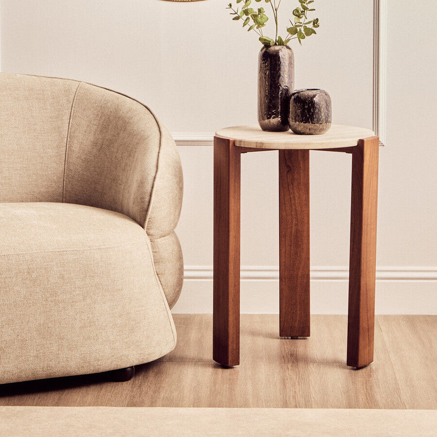 Wooden side table with two vases and a plant next to a beige armchair.