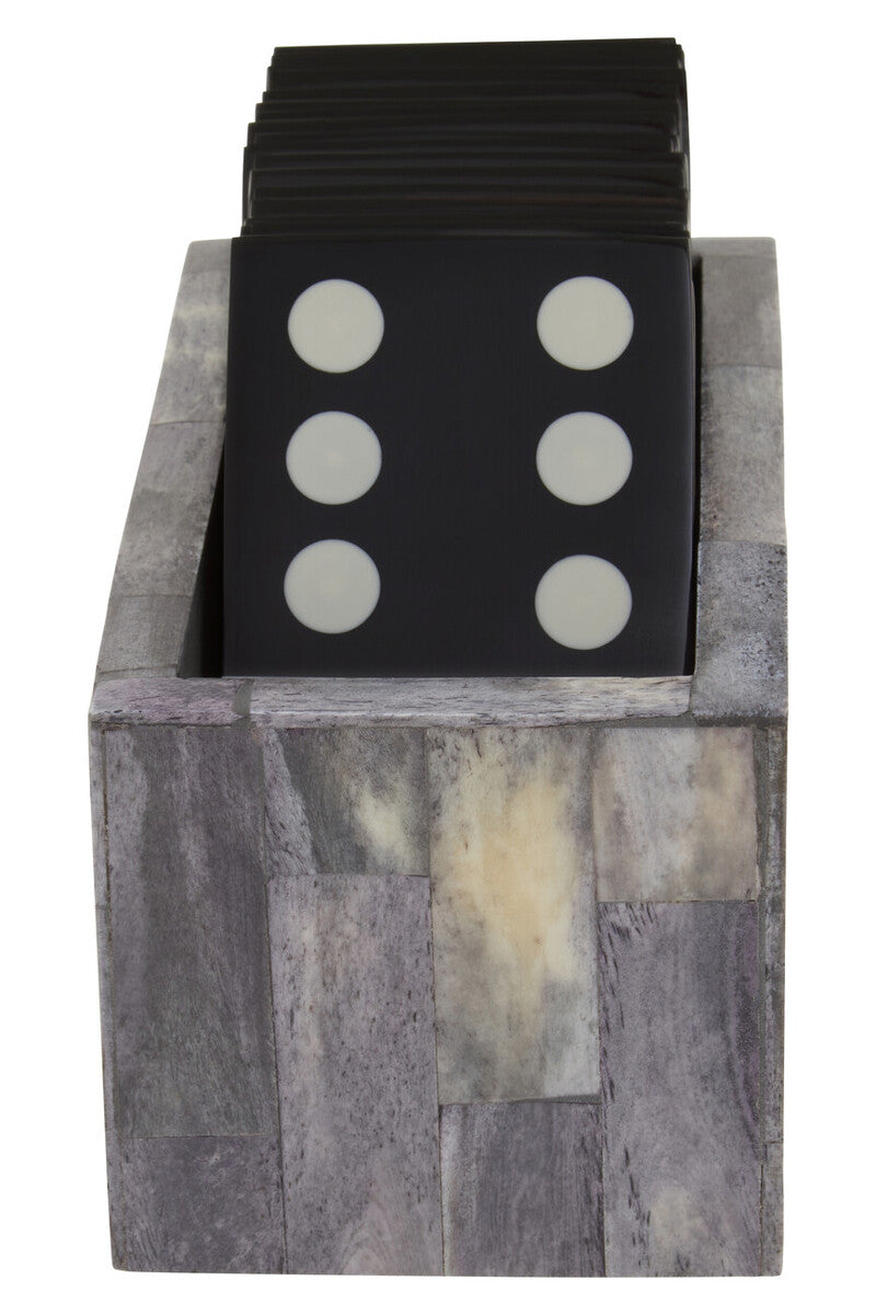 Black dice with white dots in a stone-like container on a white background