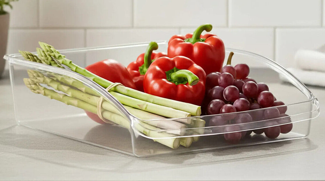 Clear plastic container with vegetables on a kitchen counter, labeled &