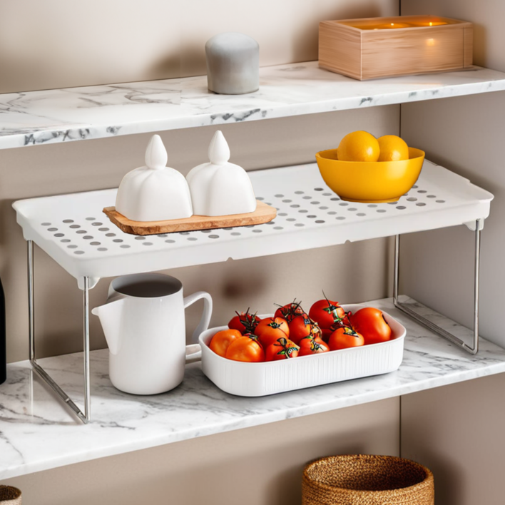 Kitchen shelves with various items including tomatoes, a pitcher, and a bowl on a marble countertop.