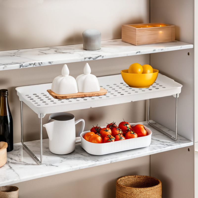 Kitchen shelves with various items including tomatoes, a pitcher, and a bowl on a marble countertop.