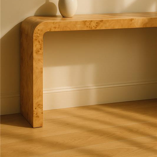 Wooden console table with a white vase and dried flowers against a beige wall.