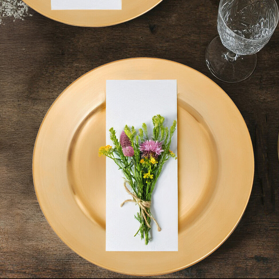Gold plates with floral arrangements on a wooden table