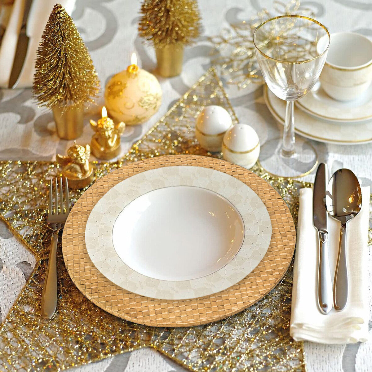 Elegant table setting with gold and white decor, including plates, glasses, and cutlery.