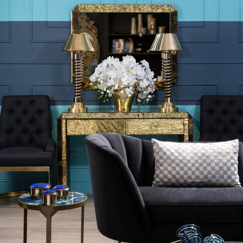Living room with dark sofa, decorative table, and blue wall.