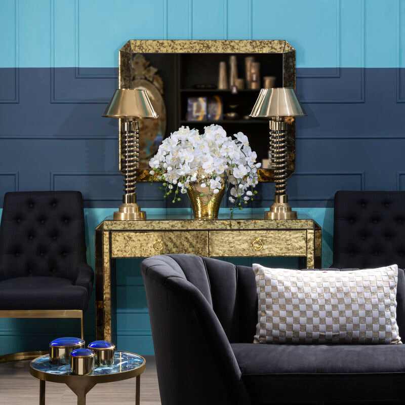 Living room with dark sofa, decorative table, and blue wall.
