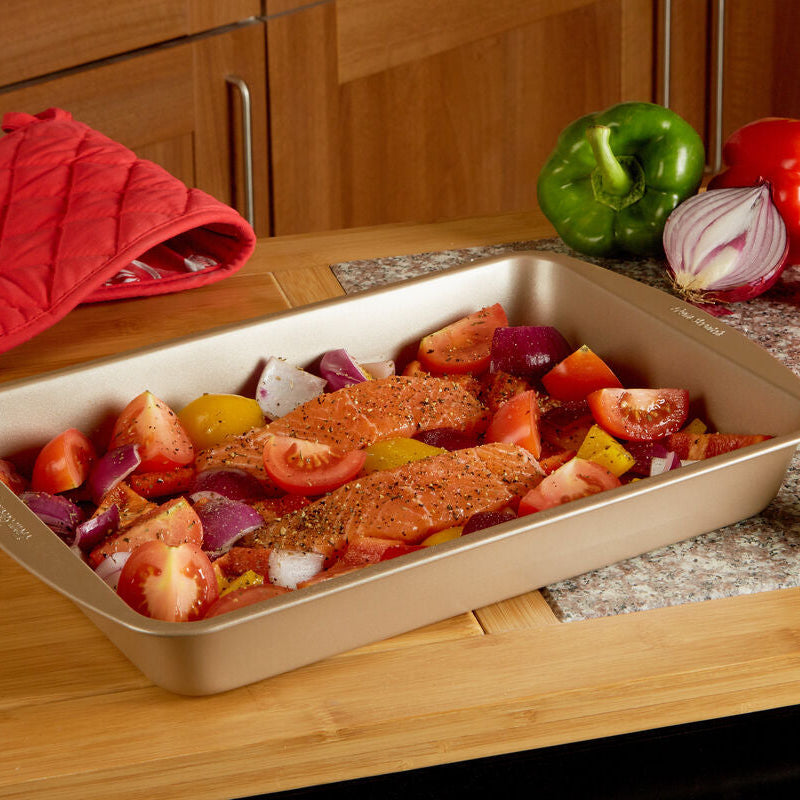 Roasting pan with salmon and vegetables on a kitchen counter