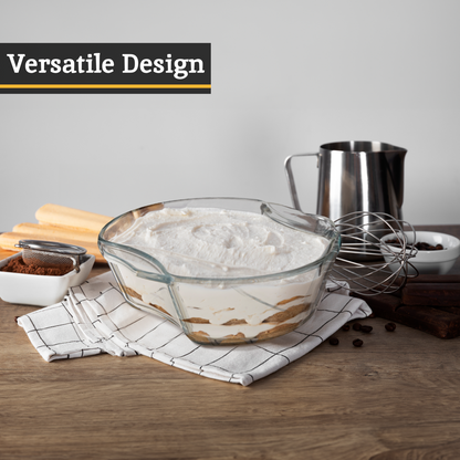 Glass mixing bowl with flour on a wooden table, surrounded by baking ingredients.