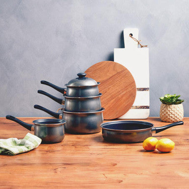 Set of cookware on a wooden surface with a neutral background