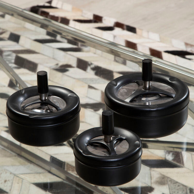 Three black wheels on a glass surface with a patterned floor in the background