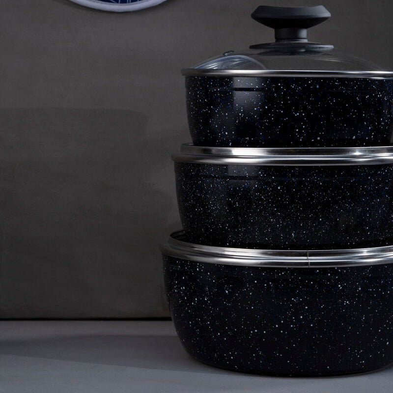 Set of black speckled cookware with silver rims on a dark background