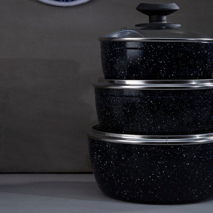 Set of black speckled cookware with silver rims on a dark background