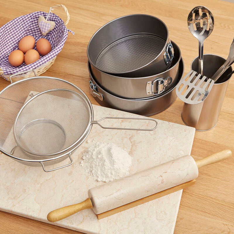 Baking utensils including a rolling pin, mixing bowl, and measuring cups on a wooden surface.