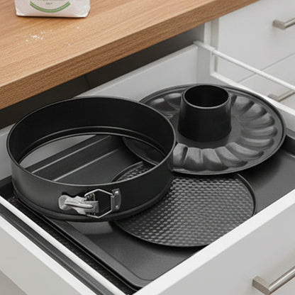Set of baking pans including a round cake pan and a bundt pan in an open kitchen drawer.