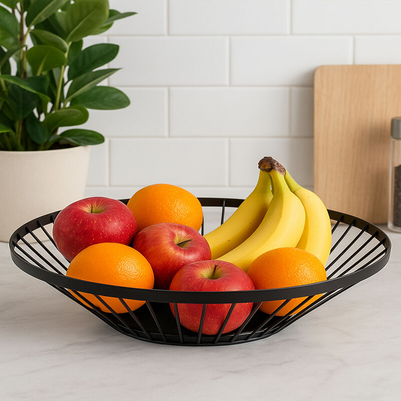 Fruit bowl with apples, oranges, and bananas on a kitchen counter.