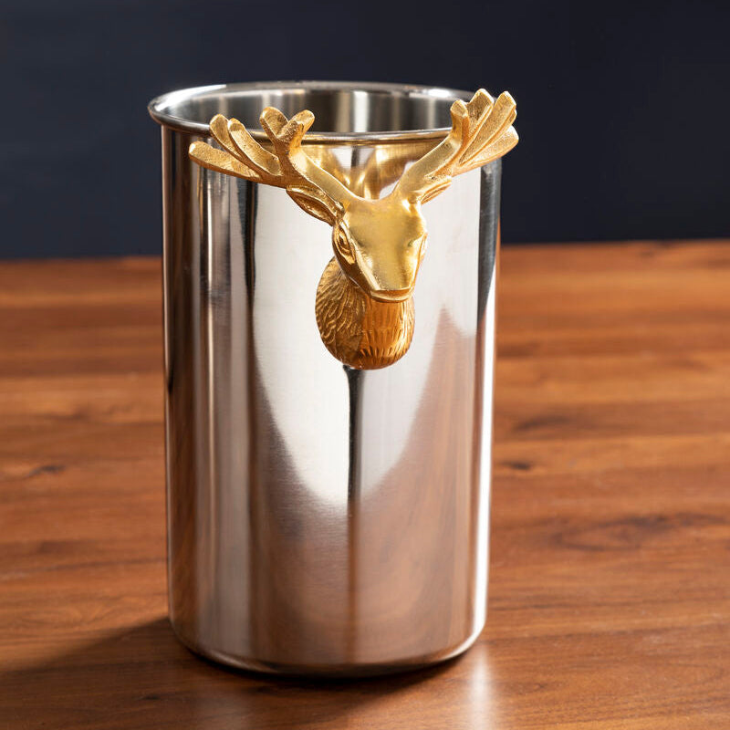 Metallic cup with gold deer head design on a wooden surface