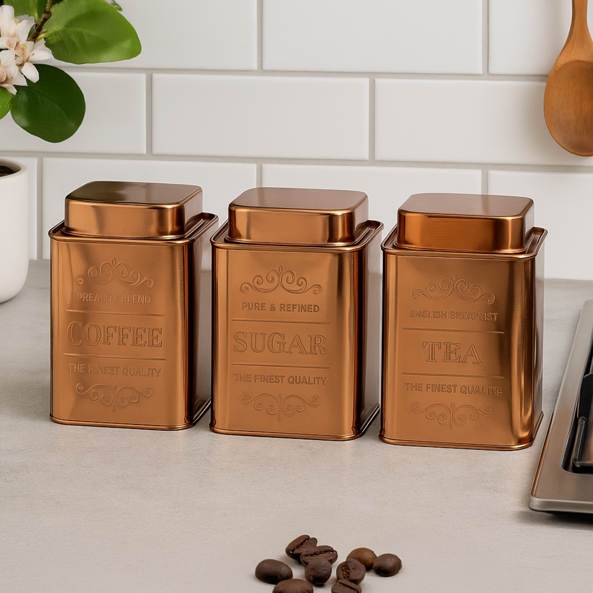 Set of three copper-colored kitchen canisters labeled &
