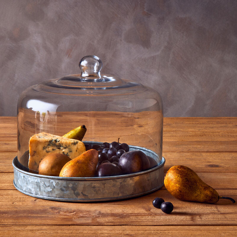 Glass cloche with food on a wooden surface