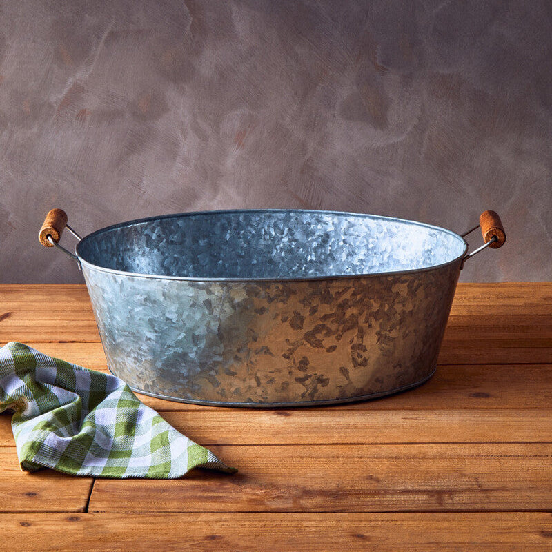 Metal basin on a wooden surface with a textured gray background