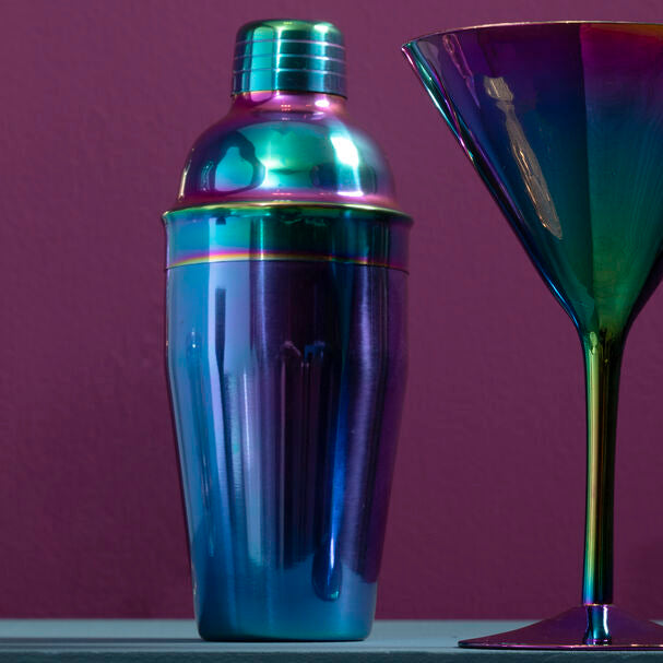 Multicolored cocktail shaker and martini glass on a purple background