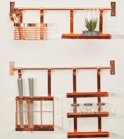 Copper wall-mounted kitchen organizer with shelves and cutlery on a white background