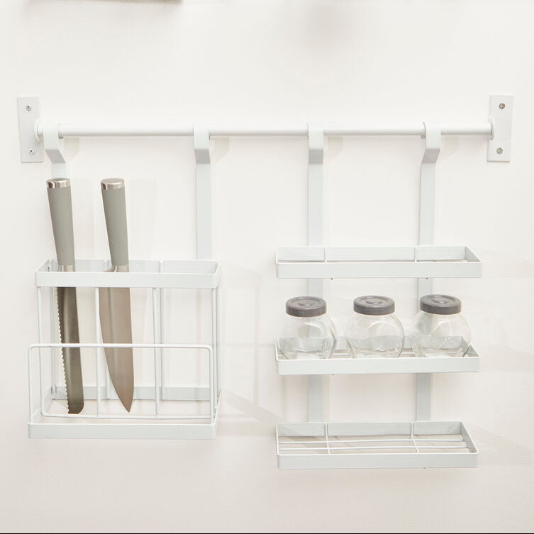 White wall-mounted shelving unit with various items on a white background