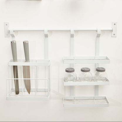 White wall-mounted shelving unit with various items on a white background