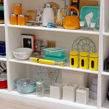 Shelving unit with kitchenware including jars, bowls, and a teapot.