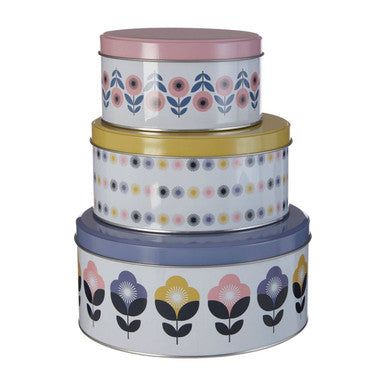 Set of three floral-patterned tins stacked on a white background